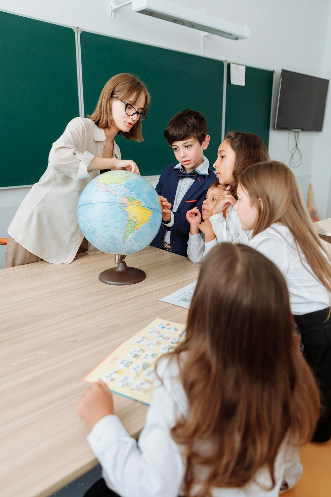 teacher teaching kids about the titanic pointing at globe